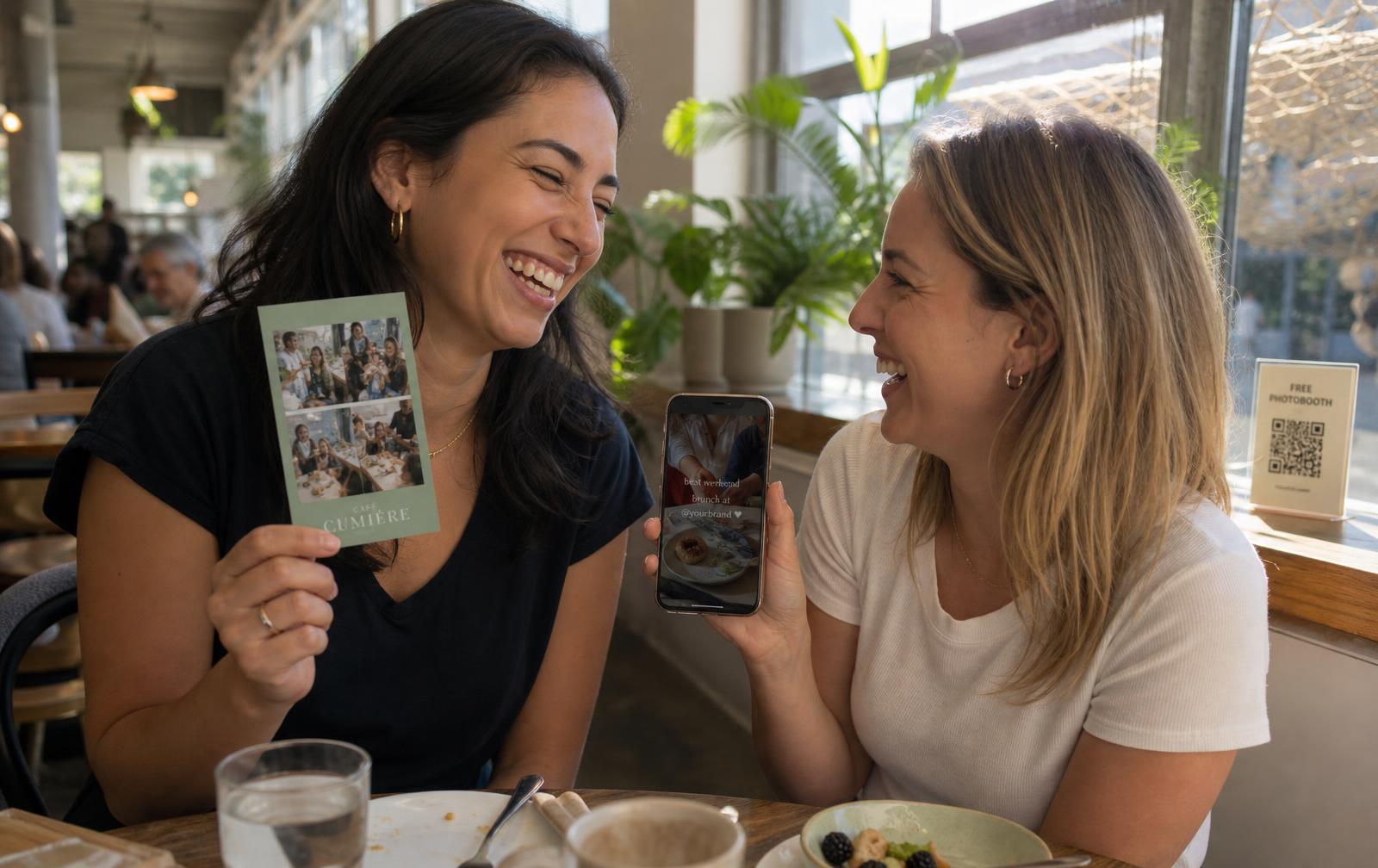Two friends at brunch with a branded photo card and a phone showing the clip from the session